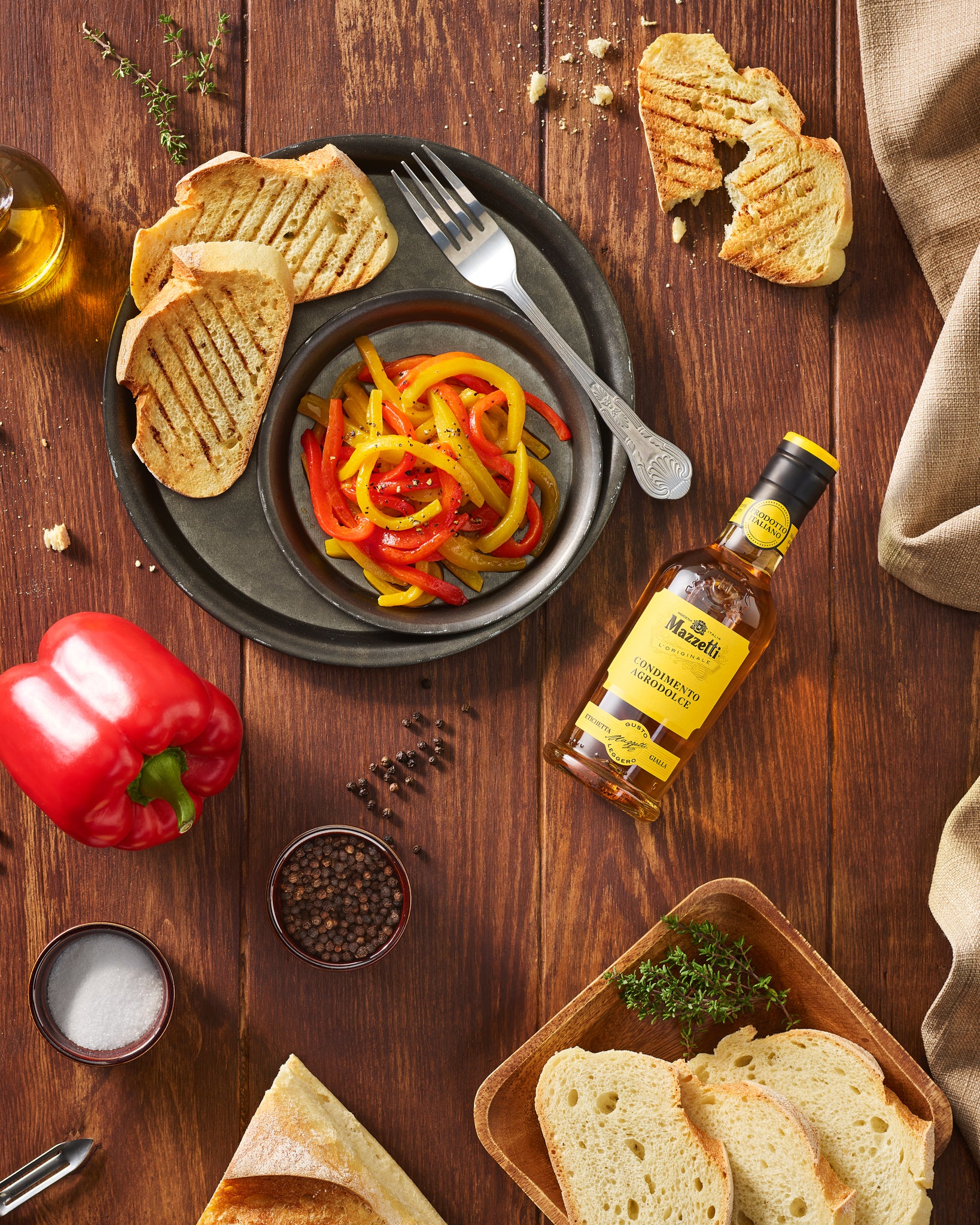 Antipasto di peperoni colorati in agrodolce con crostone di pane